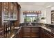 Elegant wet bar with granite countertop and glass-front cabinets at 11261 Macaw Ct, Windermere, FL 34786