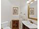 Powder room with wooden cabinet, decorative artwork, and a white sink at 11261 Macaw Ct, Windermere, FL 34786