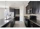 Modern kitchen with dark cabinets and granite counters at 1411 Clubman Dr, Davenport, FL 33896