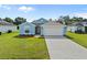 Cute light blue house with a two-car garage and well-manicured lawn at 656 Koala Ct, Kissimmee, FL 34759