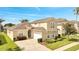 Two-story house with a tan exterior, a two-car garage, and well-maintained landscaping at 511 Pineloch Dr, Haines City, FL 33844