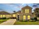 Two-story house with a tan exterior, a two-car garage, and well-maintained landscaping at 511 Pineloch Dr, Haines City, FL 33844