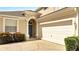 Front view of the house showing a two-car garage and a light-blue front door at 511 Pineloch Dr, Haines City, FL 33844