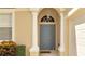 Front entrance with a gray door, white columns, and lush landscaping at 511 Pineloch Dr, Haines City, FL 33844