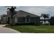 Gray house with lake view, palm trees, and paved driveway at 511 Pineloch Dr, Haines City, FL 33844