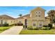 Two-story house with a tan exterior, a two-car garage, and well-maintained landscaping at 511 Pineloch Dr, Haines City, FL 33844