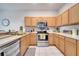 Bright kitchen with stainless steel appliances and light wood cabinets at 511 Pineloch Dr, Haines City, FL 33844