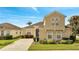 Two-story house with a tan exterior, a two-car garage, and well-maintained landscaping at 511 Pineloch Dr, Haines City, FL 33844
