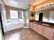 Bathroom boasts double vanity, granite countertop, and a soaking tub at 122 Stone Gable Cir, Winter Springs, FL 32708