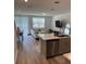 Open concept kitchen and living area with island, stainless steel appliances, and neutral decor at 2021 Crape Jasmine Ln, Orlando, FL 32824
