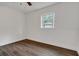 Bright bedroom with ceiling fan and window, featuring wood-look floors at 7828 Range Dr, Orlando, FL 32810