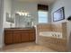 Bathroom with corner bathtub and double vanity at 7762 Linkside Loop, Reunion, FL 34747