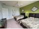 Two twin beds in a well-lit bedroom with green accent wall at 7762 Linkside Loop, Reunion, FL 34747