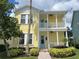 Two-story yellow house with blue door and landscaped yard at 7762 Linkside Loop, Reunion, FL 34747