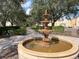 Ornate fountain in a landscaped area with walkways and trees at 7762 Linkside Loop, Reunion, FL 34747