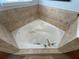 Corner soaking tub with tile surround in a spacious bathroom at 7762 Linkside Loop, Reunion, FL 34747