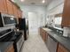Modern kitchen with stainless steel appliances and wood cabinets at 7762 Linkside Loop, Reunion, FL 34747