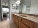 Double vanity bathroom with granite countertop, and access to bedroom at 7762 Linkside Loop, Reunion, FL 34747