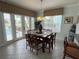 Spacious dining area with a large table, six chairs, and access to the kitchen and pool at 7762 Linkside Loop, Reunion, FL 34747