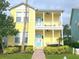 Two-story yellow house with front porch at 7762 Linkside Loop, Reunion, FL 34747