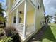 Side view of two-story yellow house with a porch and white railings at 7762 Linkside Loop, Reunion, FL 34747