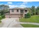 Two-story house with a three-car garage and landscaped lawn at 553 Quail Lake Dr, Debary, FL 32713