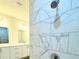 Walk-in shower with marble-look tile and modern shower fixture at 1312 Hillsborough Ct, Poinciana, FL 34759