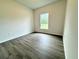 Simple bedroom with wood-look floors and a window providing natural light at 1312 Hillsborough Ct, Poinciana, FL 34759