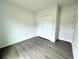 Well-lit bedroom featuring wood-look floors and double-door closet at 1312 Hillsborough Ct, Poinciana, FL 34759