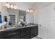 Double vanity bathroom with dark cabinets and large mirror at 1455 Alston Bay Blvd, Apopka, FL 32703