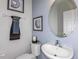 Small half bathroom with pedestal sink and oval mirror at 1455 Alston Bay Blvd, Apopka, FL 32703