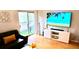 Living room with a large TV, balcony access, and hardwood floors at 1990 Erving Cir # 201, Ocoee, FL 34761