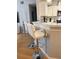 Modern kitchen island with white quartz countertop and two white leather barstools at 1990 Erving Cir # 201, Ocoee, FL 34761