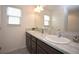 Double vanity bathroom with dark brown cabinets and marble countertops at 11188 Hess Way, Oxford, FL 34484