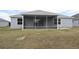 Single-story house with screened porch and grassy backyard at 11188 Hess Way, Oxford, FL 34484