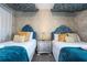 Two twin beds with teal blankets and gold accents in a well-decorated bedroom at 4837 Dedication St, Kissimmee, FL 34746