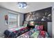 Superhero themed bedroom with twin beds, large mural, and window with blinds at 936 Paradise Dr, Davenport, FL 33897