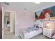 Twin-size beds in a bright bedroom with Ariel mural at 936 Paradise Dr, Davenport, FL 33897