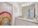 Clean bathroom with double sinks, granite countertops, and rainbow shower curtain at 936 Paradise Dr, Davenport, FL 33897