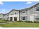 Row of townhouses with gray siding, landscaping, and walkway at 936 Paradise Dr, Davenport, FL 33897