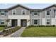 Two-story townhome with gray siding, landscaped lawn, and walkway at 936 Paradise Dr, Davenport, FL 33897