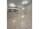 Open living room with tile flooring and kitchen access at 5578 Metrowest Blvd # 107, Orlando, FL 32811