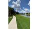 Concrete walkway alongside a grassy area and lake at 5578 Metrowest Blvd # 107, Orlando, FL 32811