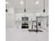 Modern kitchen with white cabinets, quartz countertops, and a black faucet at 5277 Sw 165Th Street Rd, Ocala, FL 34473