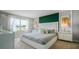 Spacious main bedroom with a large window, green accent wall, and plush bedding at 3901 Botancial Court, Sanford, FL 32773
