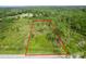 Buildable lot outlined in red, surrounded by trees at 30808 Apricot Ave, Eustis, FL 32736