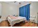 Bedroom with a queen-size bed, wood floors, and blue curtains at 701 Castlewood Dr, Winter Springs, FL 32708