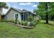 Backyard view of house, showing landscaping, lawn, and screened porch at 701 Castlewood Dr, Winter Springs, FL 32708