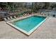 Community pool with surrounding lounge chairs and tennis courts in the background at 701 Castlewood Dr, Winter Springs, FL 32708