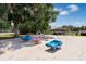 Community playground with swings, slides, and spring toys under a large tree at 701 Castlewood Dr, Winter Springs, FL 32708
